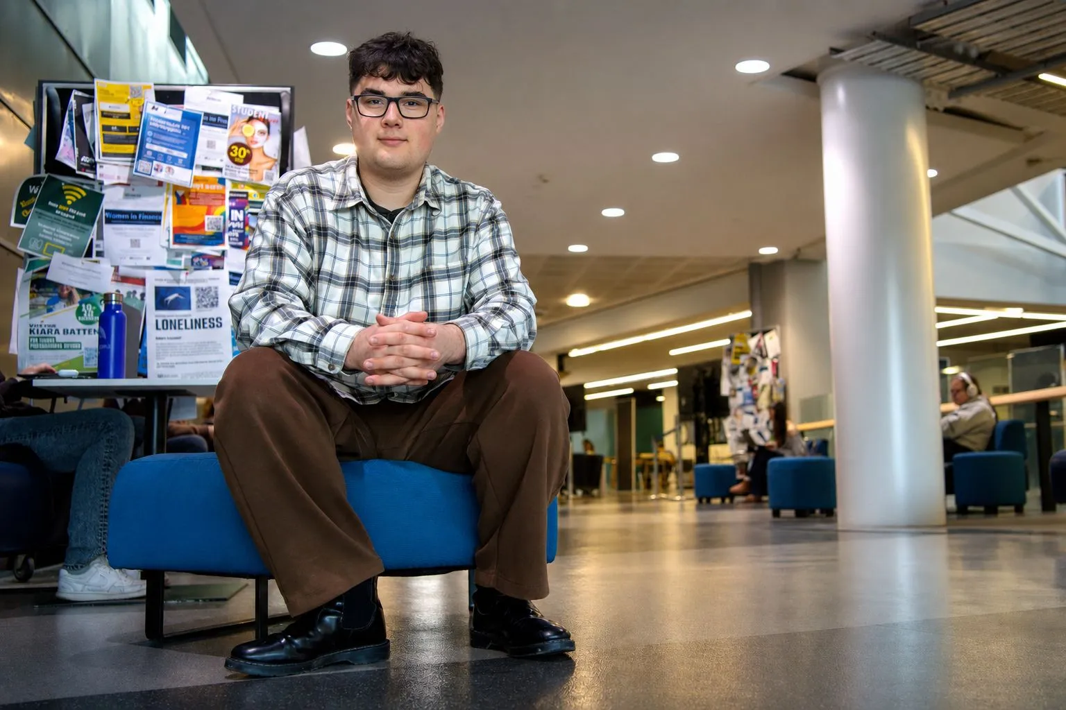 Arie Joe seated in a campus common area.
